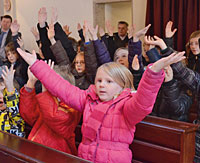 Kleine Kinder lauschen das Gebet von Mama und Papa ab